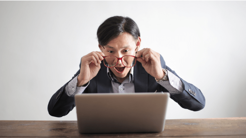 A man sitting at a desk looking amazed